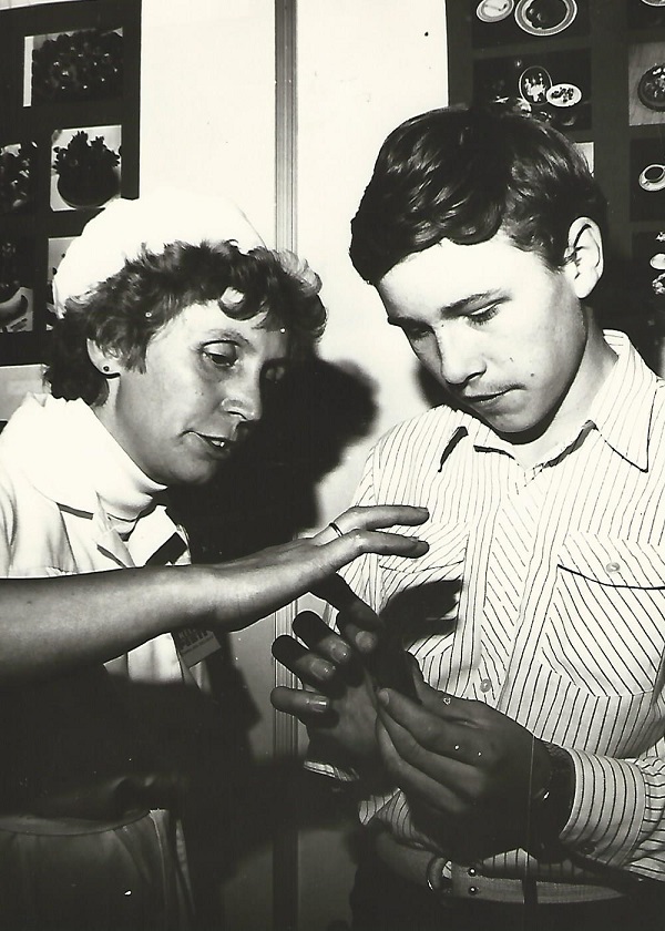 A Kelet-Pesti Vendéglátóipari Vállalat cukrásza mutatja a marcipánrózsa készítésének fogásait egy érdeklődő diáknak, 1983 - Magyar Kereskedelmi és Vendéglátóipari Múzeum, CC BY-NC-ND